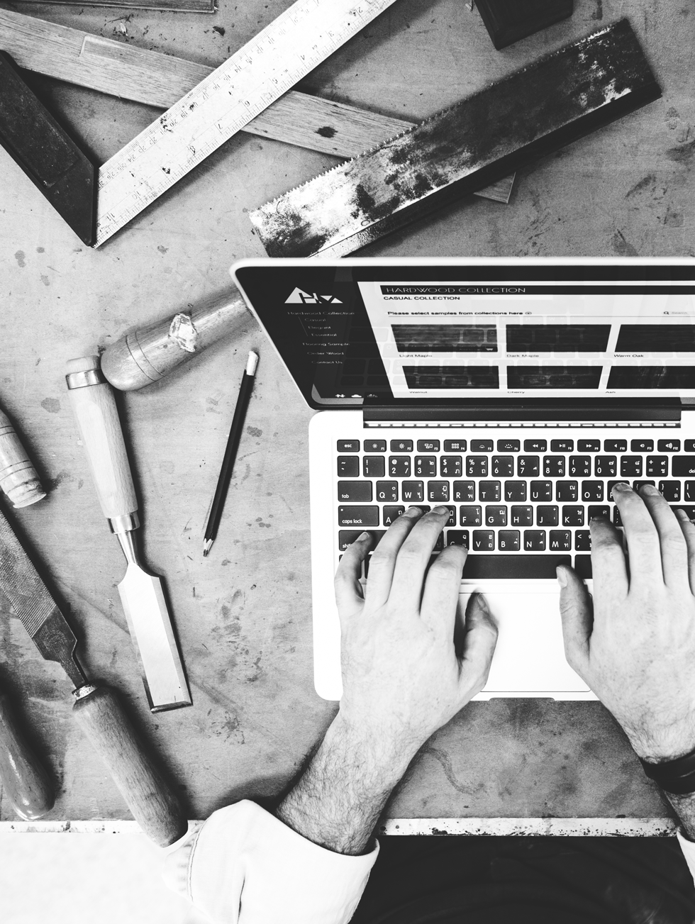 Artisan travaillant sur son site WordPress, ordinateur entouré d’outils de menuiserie, ambiance atelier