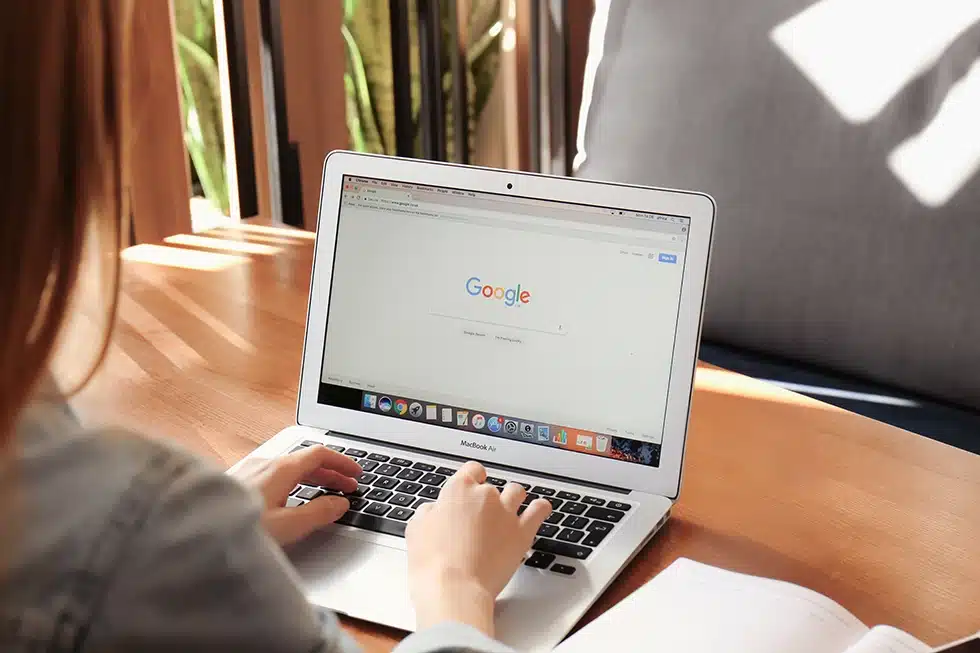 Personne effectuant une recherche sur Google depuis un ordinateur portable — illustration de la visibilité en ligne et du référencement d’un site internet.